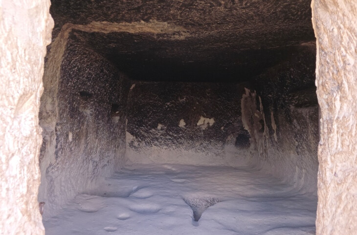 Göreme Açık Hava Müzesi’ndeki kaya oyma mutfak odası, duvarlarda is lekeleri, nişler ve zeminde oyuklar görülüyor.